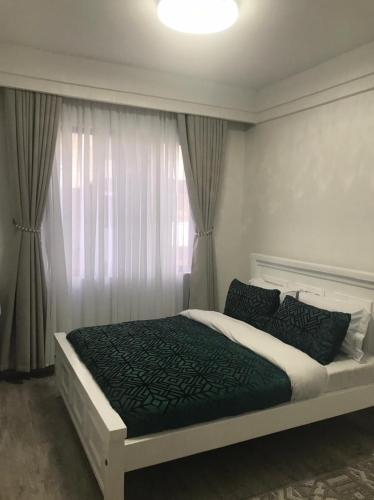 a bedroom with a bed and a window at Imani Homes in Nairobi