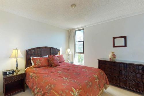 - une chambre avec un lit doté de draps rouges et une fenêtre dans l'établissement Maui Kai 508, à Kaanapali Airport