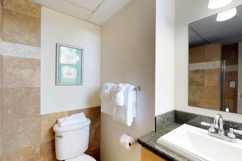 une salle de bain avec toilettes, lavabo et miroir dans l'établissement Maui Kai 508, à Kaanapali Airport
