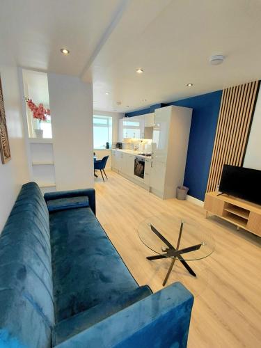 a living room with a blue couch and a table at Blue Door Apartments in Dover