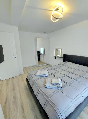 a bedroom with a large bed with towels on it at Blue Door Apartments in Dover