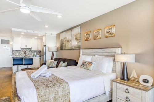 a bedroom with two beds and a kitchen at Maui Kai 707 in Kaanapali Airport