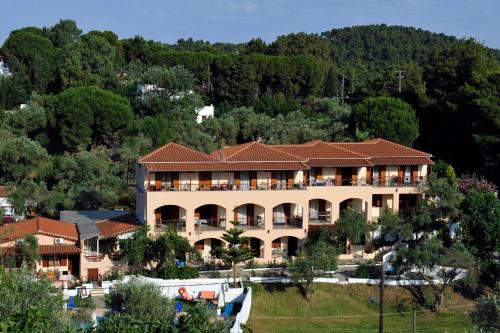 a large building with a mountain in the background at Hotel Marina in Kolios