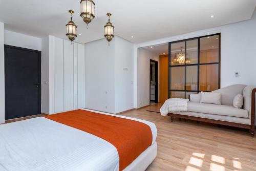 a bedroom with a large bed and a couch at Villa Anzar Refined Oasis wChef and Emerald Hammam in El Rhechat