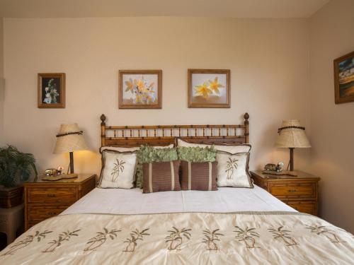 a bedroom with a large bed with pillows and two lamps at Wailea Grand Champions 111 in Wailea