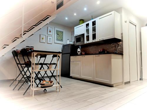 a kitchen with white cabinets and a staircase at Akihome Portanova in Naples