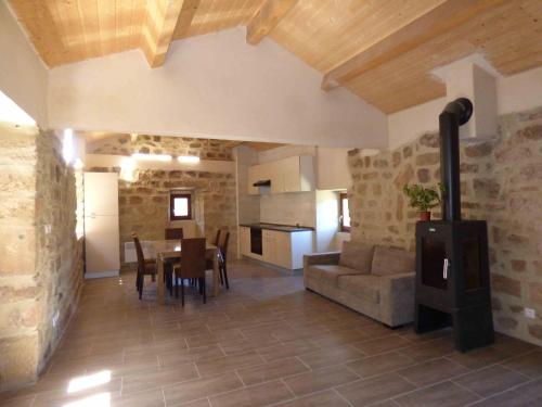 une cuisine et un salon avec une table et un canapé dans l'établissement Hameau de Gratte, à Faugères