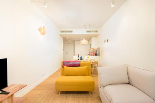 a living room with a couch and a yellow chair at Porto de Gaia in Vila Nova de Gaia