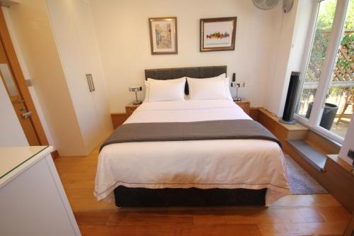 een groot bed in een kamer met 2 ramen bij Cambridge city centre immaculate 2 bed apartment in Cambridge