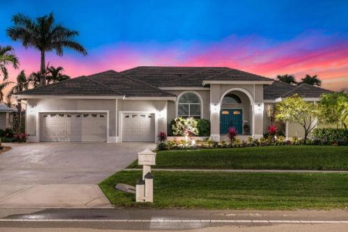 a house with a garage at sunset at Island Twilight Delight in Marco Island