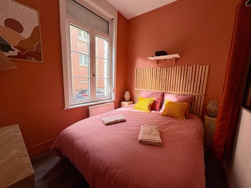 a bedroom with a large bed with yellow pillows at Grand Place Arras RDC 4 pers vidéoprojecteur in Arras