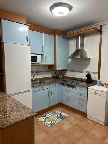 a kitchen with blue cabinets and a sink at Vivienda vacacional: Los Abuelos in San Vicente de la Barquera