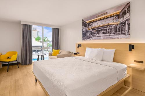 a hotel room with a large bed and a desk at B&B HOTEL Orlando International Drive near Universal - Newly Renovated! in Orlando