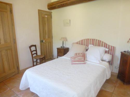 a bedroom with a white bed with two pillows on it at B&B Les Argiles in Mérindol