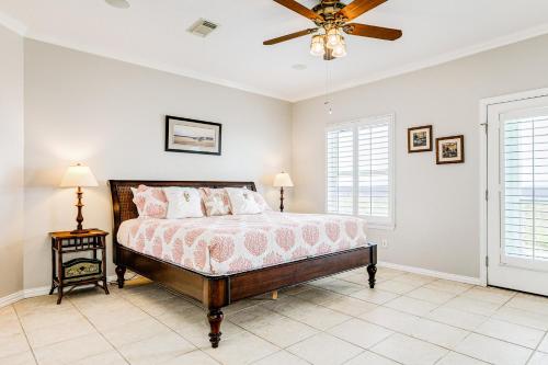 a bedroom with a bed and a ceiling fan at Ultimate Beachfront Beach Access Fenced Yard in Hercules Offshore Heliport