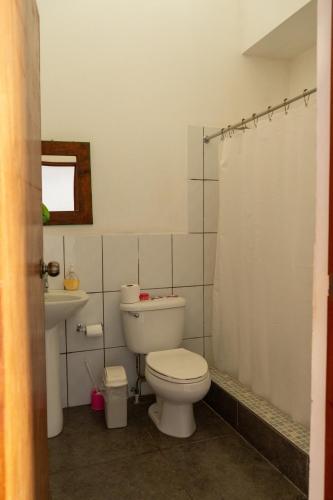 a bathroom with a toilet and a shower curtain at Hostal Casa del Sol Apartamento in Suchitoto