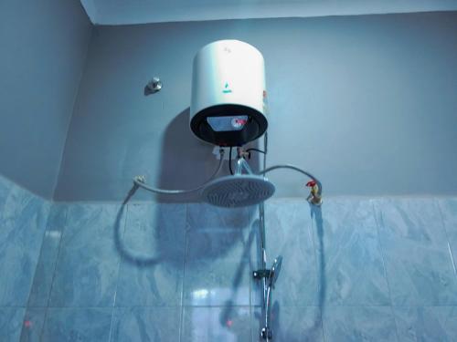 a shower with a shower head in a bathroom at Creation Homes Uganda in Tororo