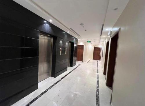 un couloir avec des murs noirs et blancs et un long couloir dans l'établissement فندق شركة وردة الوادي توصيل من والي الحرم 24 مجاني, à An Naqāʼ