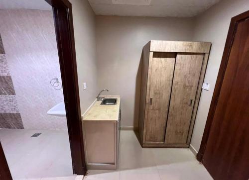 La salle de bains est pourvue d'un lavabo et d'une armoire en bois. dans l'établissement فندق شركة وردة الوادي توصيل من والي الحرم 24 مجاني, à An Naqāʼ