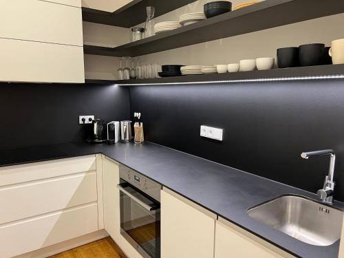 a kitchen with white cabinets and a sink at CITY CENTRUM CHARMING apartment in Prague