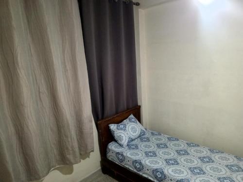a bedroom with a bed and a curtain with a pillow at KASBAH Guests Travel in Fès
