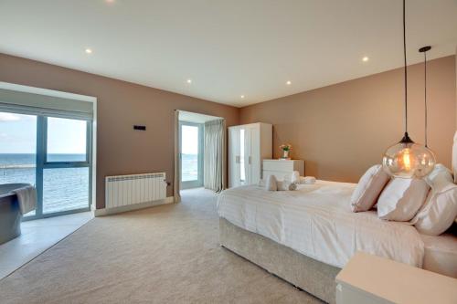 シーハウシズにあるWater's Edge at Farne House, Seahousesの大きな白いベッドと大きな窓のある寝室