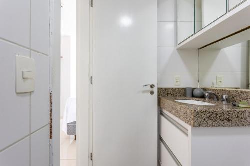 a bathroom with a sink and a mirror at TOP 10 apartamento dentro do shopping in Brasilia