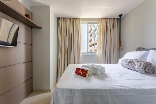 a bedroom with a white bed with two towels on it at TOP 10 apartamento dentro do shopping in Brasilia