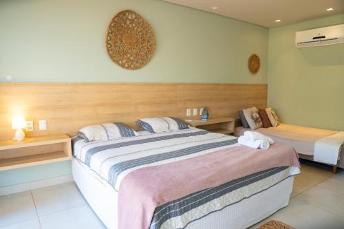 a hotel room with two beds and two tables at Villas BobZ Ap 110 in Barrinha