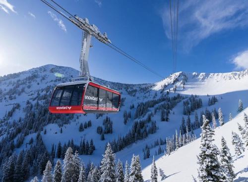 a ski lift flying over a snow covered mountain at Ski-In Ski-Out - The Cliff @ Snowbird in Sandy