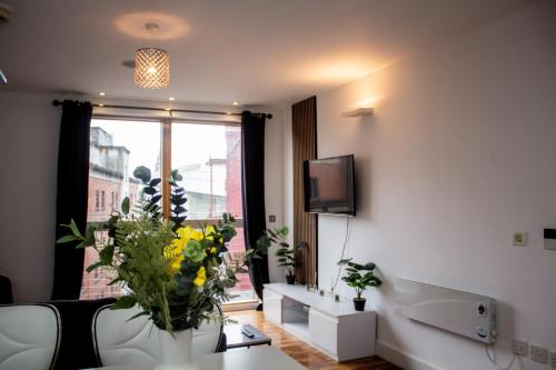 a living room with a couch and a window with flowers at Modern 2 Bed City Center Apartment in Manchester