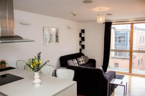 a living room with a couch and a table at Modern 2 Bed City Center Apartment in Manchester
