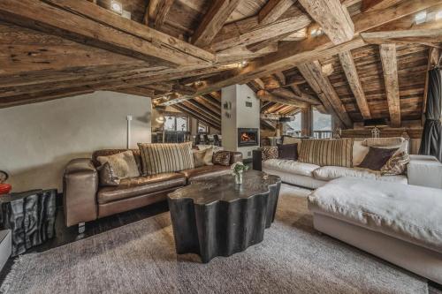 a living room with couches and a table at Chalet Rte Brigues Courchevel in Courchevel
