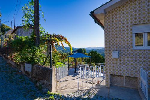 a table with an umbrella next to a building at Casa da Boavista in Amarante