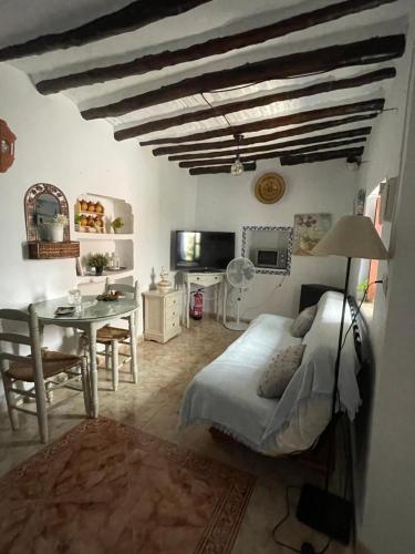 a bedroom with a bed and a desk and a table at Casa Miguelito in Comares