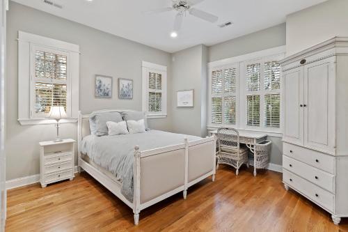 a bedroom with a white bed and two windows at SS162: 162 Surfsong Road in Kiawah Island