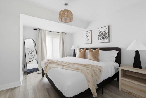 une chambre blanche avec un grand lit blanc avec des oreillers dans l'établissement Family-Friendly Modern 4-Bedroom Getaway in TO, à Toronto