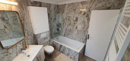 a bathroom with a sink and a toilet and a mirror at Superbe logement au style Londonien Avec Cinema Ideal pour des grandes familles et professionnels in Drancy