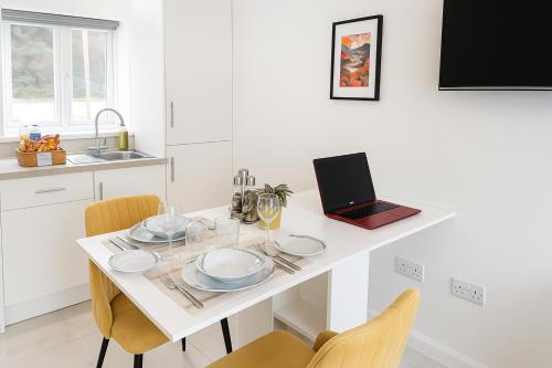 a white kitchen with a table with a laptop on it at The Nest-Free Parking Cosy Studio, M40 access, underfloor heating in High Wycombe