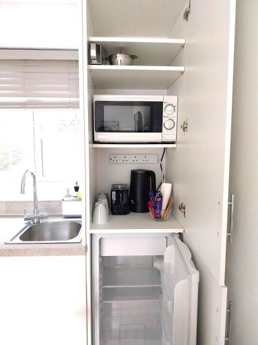 a small kitchen with a sink and a microwave at The Nest-Free Parking Cosy Studio, M40 access, underfloor heating in High Wycombe