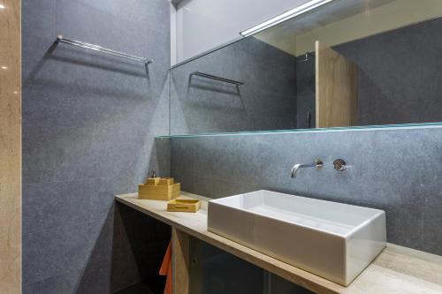 La salle de bains est pourvue d'un lavabo blanc et d'un miroir. dans l'établissement Apartament Major 33, à Arbós