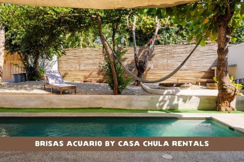 a pool in a yard with a chair and a fence at Beautiful Remodeled Studio In The Center La Punta in Brisas de Zicatela