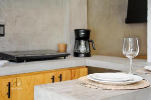 a table with a plate and a glass of wine at Beautiful Remodeled Studio In The Center La Punta in Brisas de Zicatela