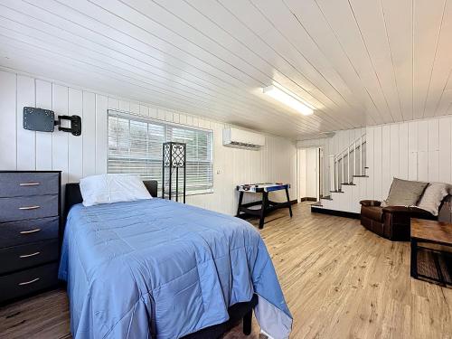 ジャクソンビルにあるSpacious 4-BR Home, 7 miles to TIAA Bank Fieldの青い掛け布団と椅子が置かれたベッドのある寝室