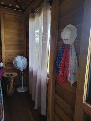a room with a window with a curtain and a fan at Cabaña Doña Flor in Turrialba