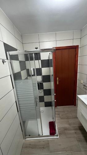a shower in a bathroom with a red door at Vistas al Mar in Tacoronte