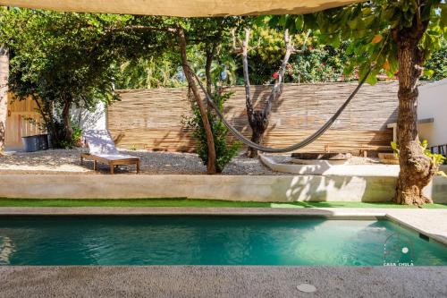 a swimming pool in a yard with a bench at Unmatched And New Studio Apartment Center La Punta in Brisas de Zicatela