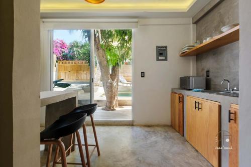 a kitchen with two stools and a kitchen with a window at Unmatched And New Studio Apartment Center La Punta in Brisas de Zicatela