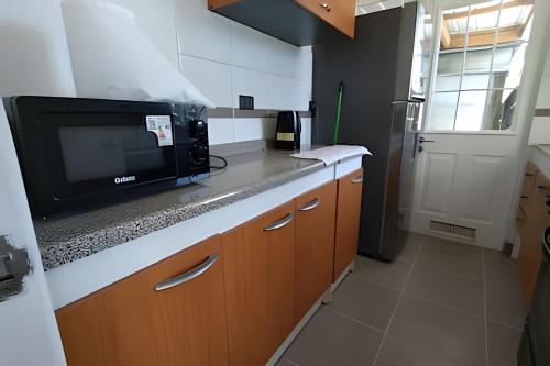 プエルトモントにあるCasa cómoda y espaciosa en Puerto Monttのカウンターの上に電子レンジがあるキッチン