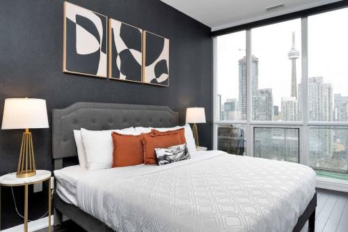 a bedroom with a large bed and a large window at Glamorous City Escape King Bed & CN Tower Views in Toronto